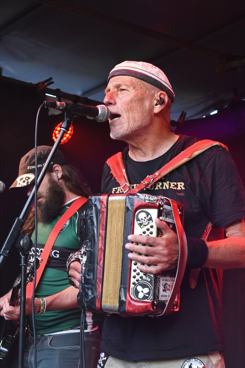 Zingende accordeonist met band op het podium