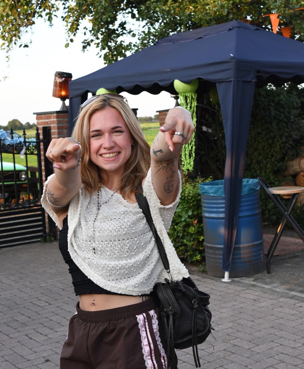 Een bezoeker wijst lachend naar de camera
