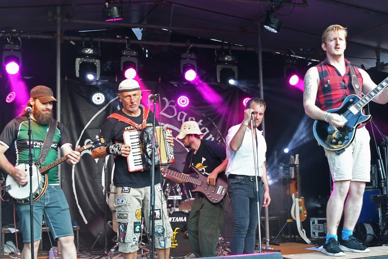 Een band met banjo, accordeon en gitaren op het hoofdpodium